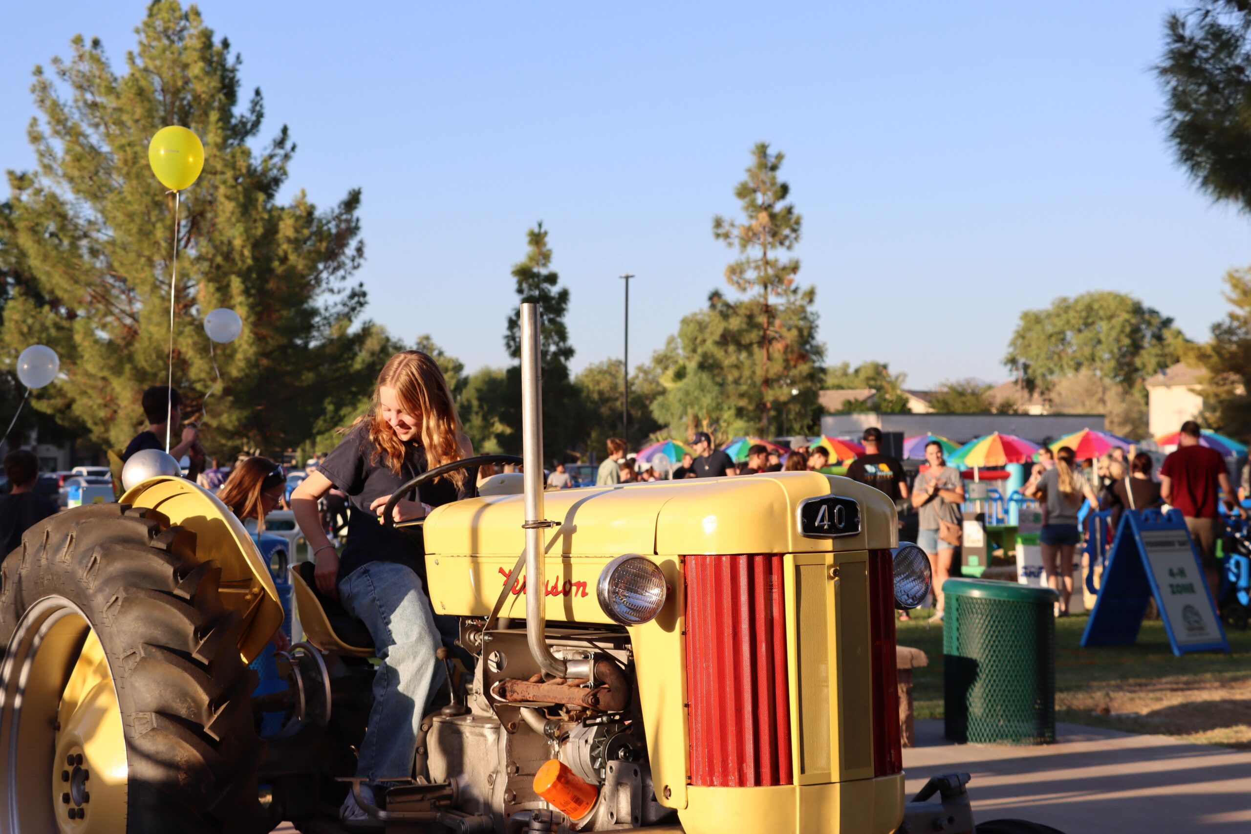 Capturing the essence of community spirit by showcasing a child enjoying a tractor at the Founders' Day event in Queen Creek.