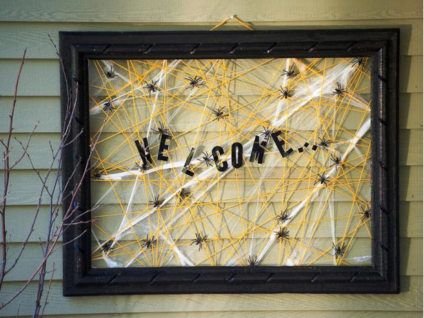 A spooky porch detail that inspires a DIY welcome sign with webs and spiders.